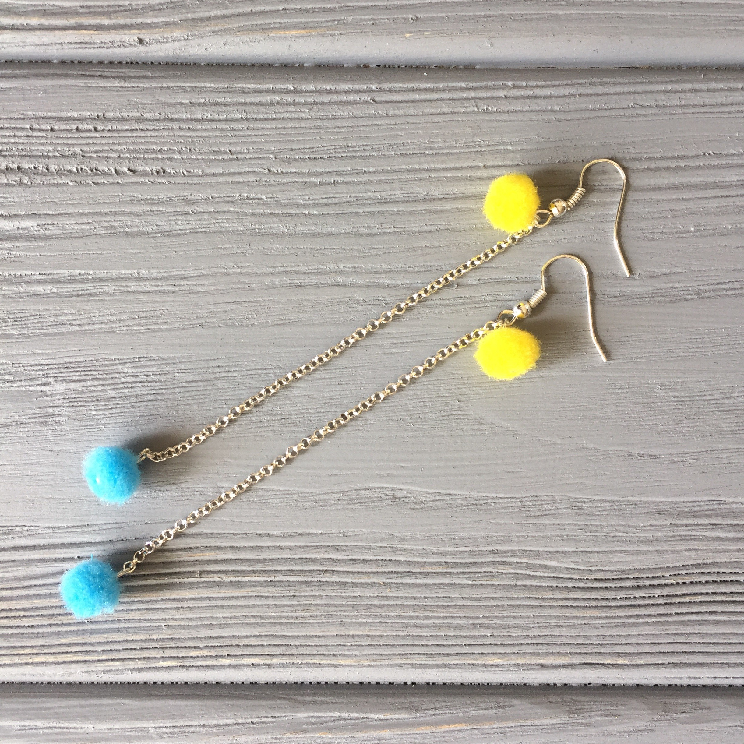 Two pompoms attached to the chain of future earrings